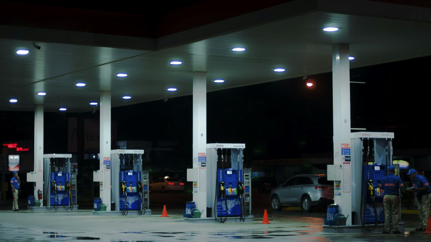 Night gas station with pumps under a lit canopy