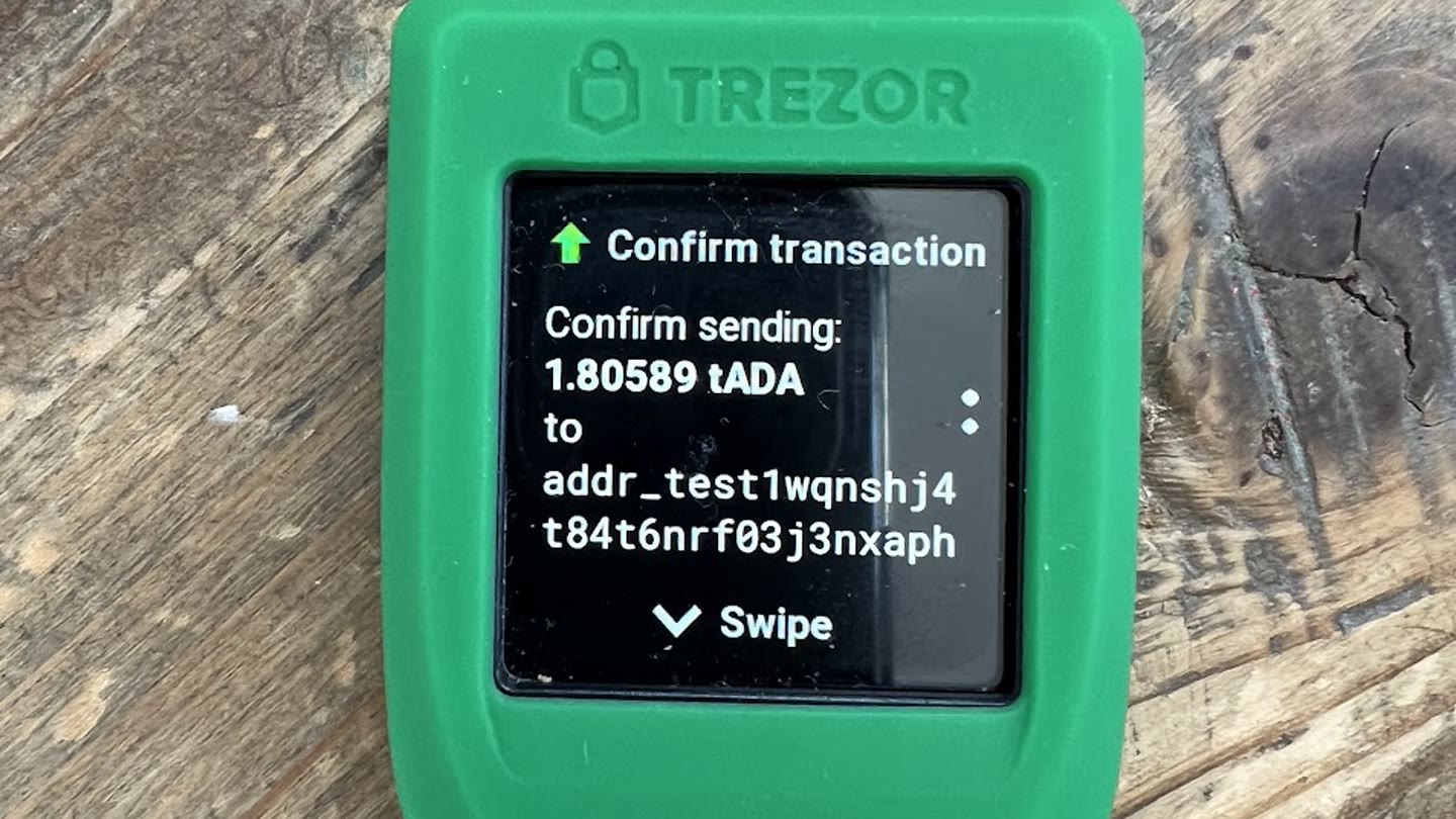 Trezor hardware wallet showing Confirm transaction and a receiving address on its screen