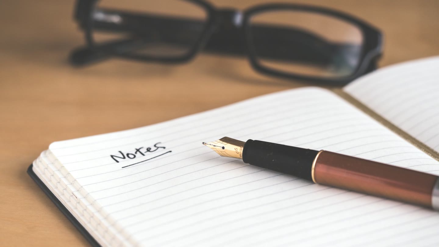 Open notebook with a fountain pen, the way a recovery phrase gets written down