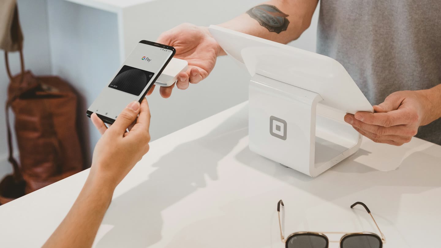 Phone tapping Google Pay on a shop card reader