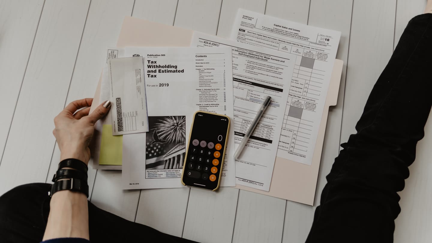 Tax forms, a calculator and a check on a desk
